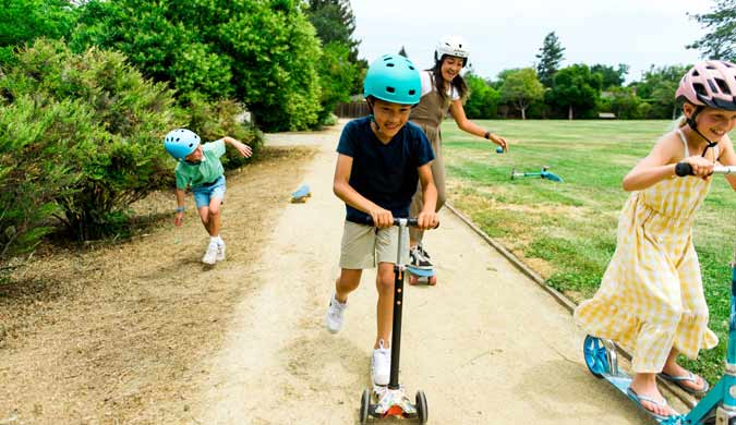 Kids on scooters and skateboards in Roseville at Adam Baquera Park